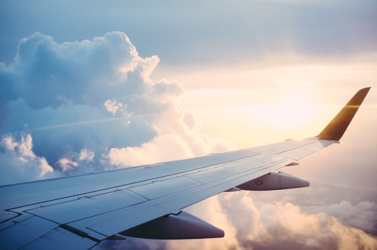 Airplane wing view from a window seat above the clouds
